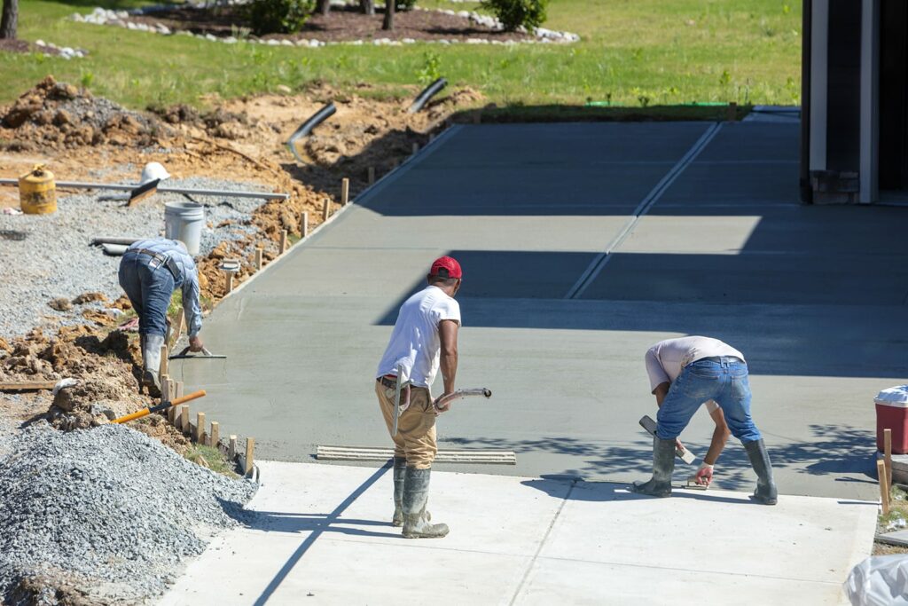 A DC Byers crew can add driveway maintenance to our services if your project is in a heavy trafficked area. Workers pour concrete for an extra wide driveway.