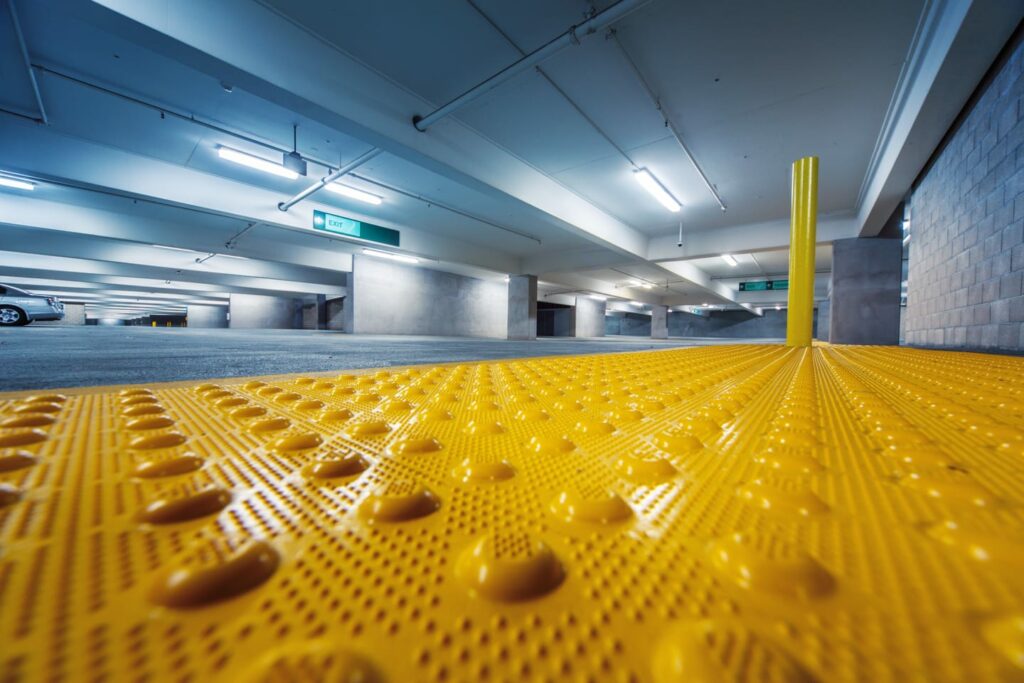 Floor safety takes many forms, yellow raised bumps in a parking structure for the visually impaired.