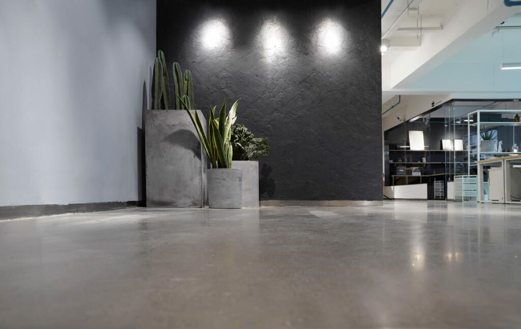 A resealed concrete floor in a modern office building lobby.