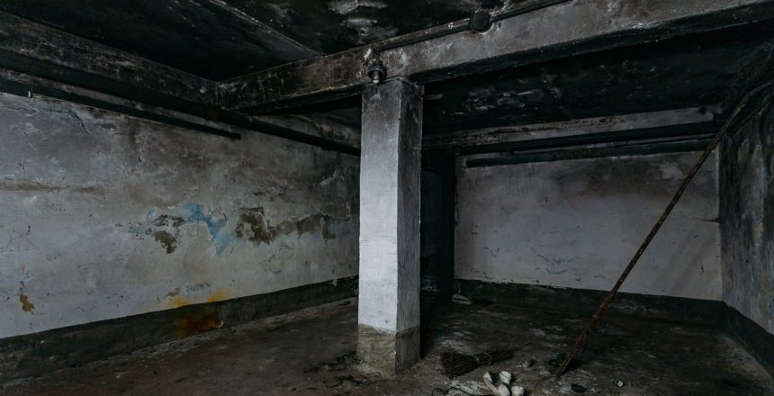 A basement room with fire damaged concrete